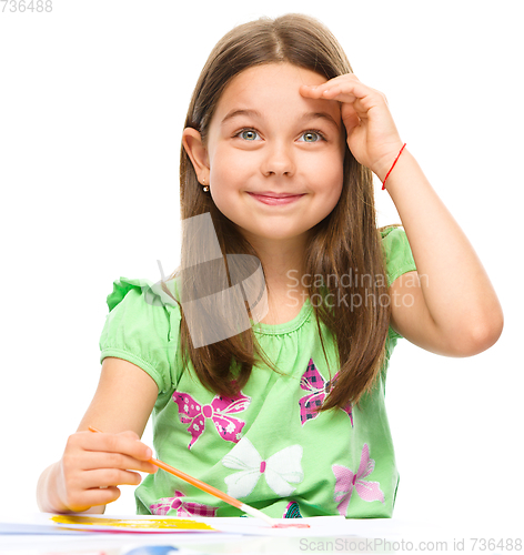 Image of Little girl is painting with gouache