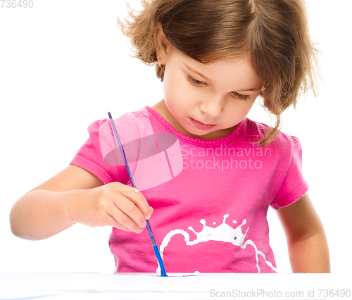 Image of Little girl is painting with gouache