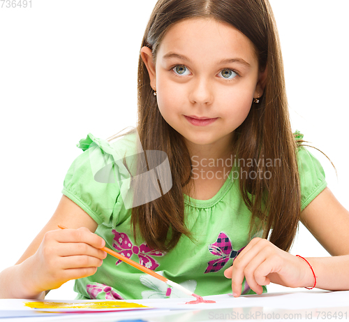 Image of Little girl is painting with gouache