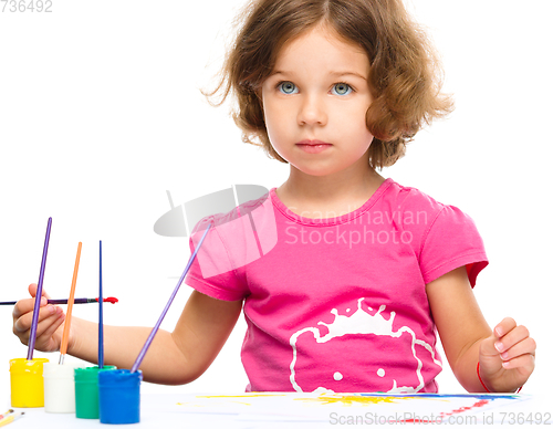 Image of Little girl is painting with gouache