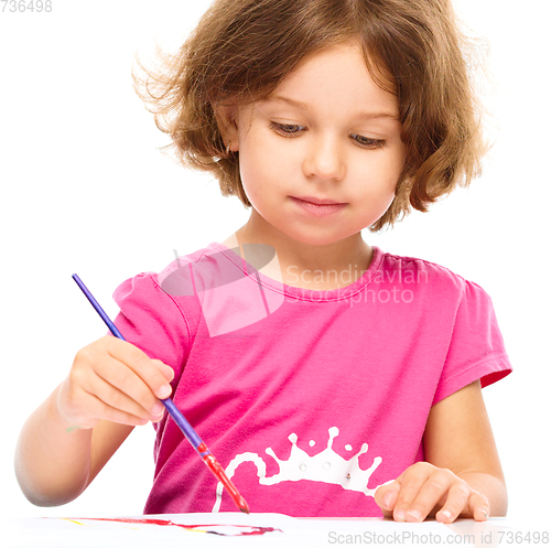 Image of Little girl is painting with gouache