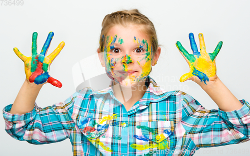 Image of Portrait of a cute girl playing with paints