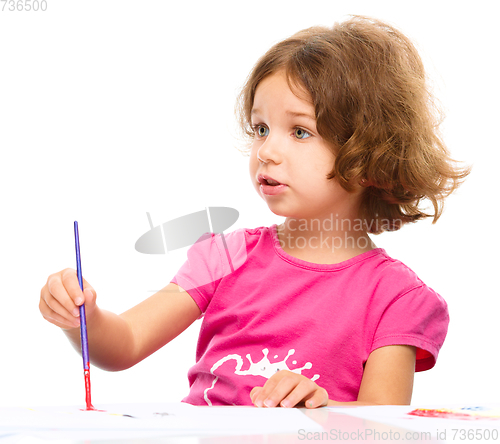 Image of Little girl is painting with gouache