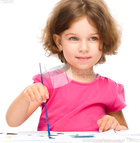 Image of Little girl is painting with gouache