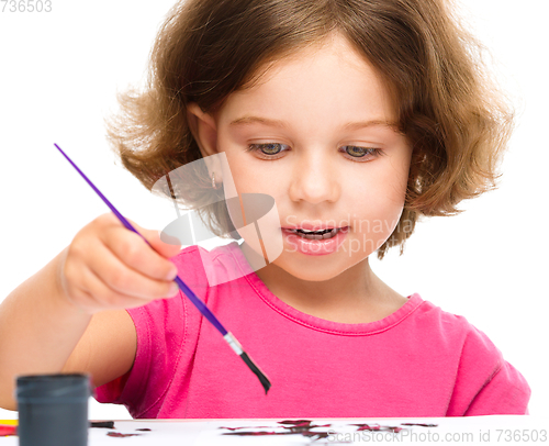 Image of Little girl is painting with gouache