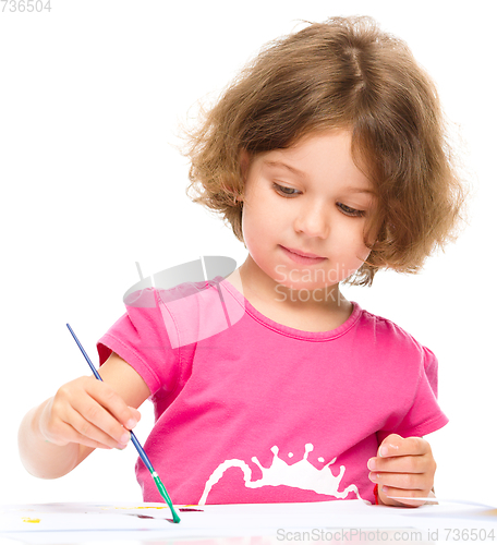 Image of Little girl is painting with gouache