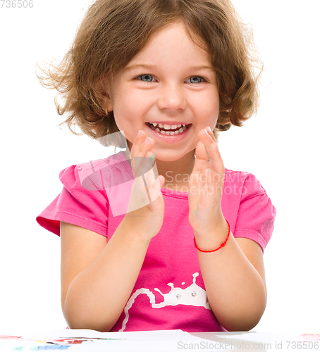 Image of Little girl is painting with gouache