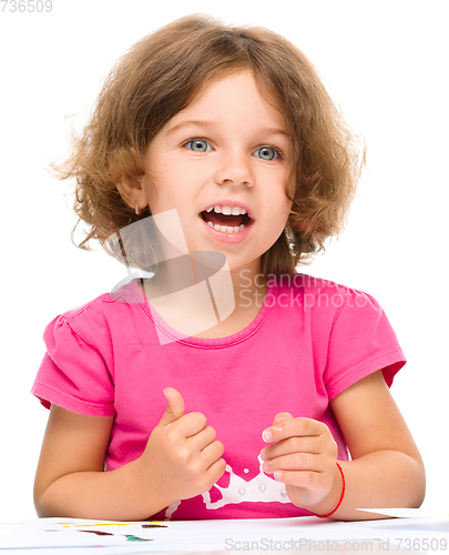 Image of Little girl is painting with gouache