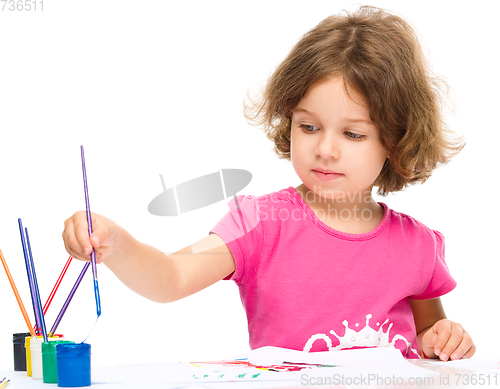 Image of Little girl is painting with gouache