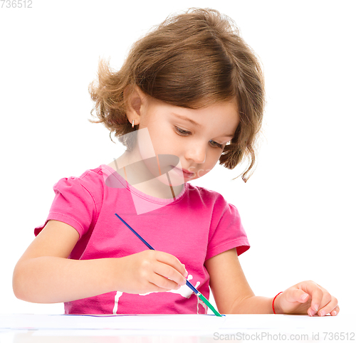 Image of Little girl is painting with gouache