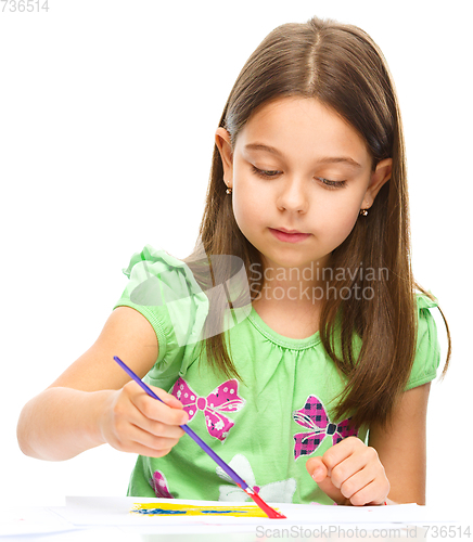 Image of Little girl is painting with gouache