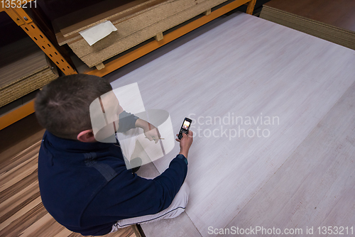 Image of carpenter using a mobile phone to calculate measures