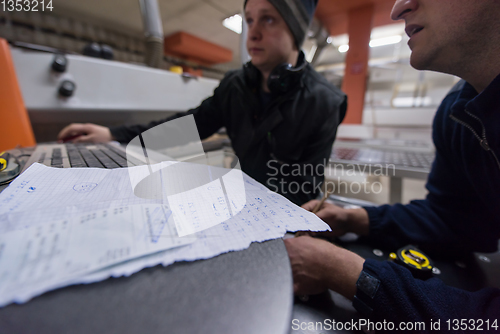 Image of carpenters calculating and programming a cnc wood working machin