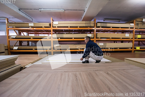 Image of carpenter measuring wooden board