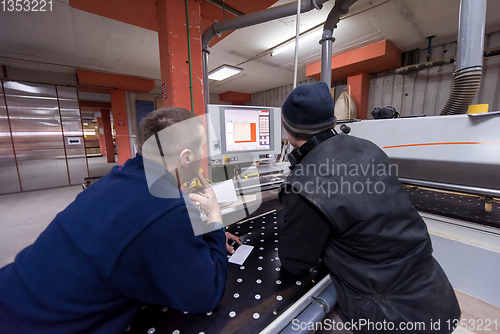 Image of carpenters calculating and programming a cnc wood working machin