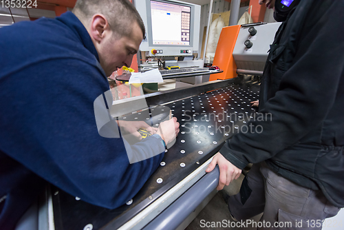 Image of carpenters calculating and programming a cnc wood working machin