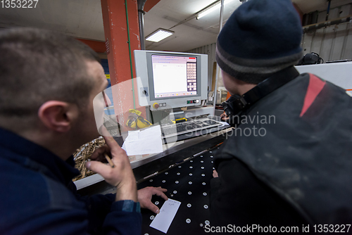 Image of carpenters calculating and programming a cnc wood working machin