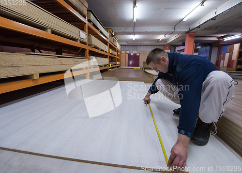 Image of carpenter measuring wooden board