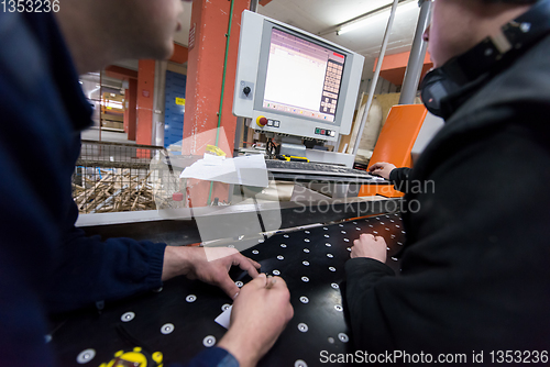 Image of carpenters calculating and programming a cnc wood working machin