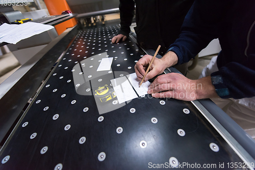 Image of carpenters calculating and programming a cnc wood working machin