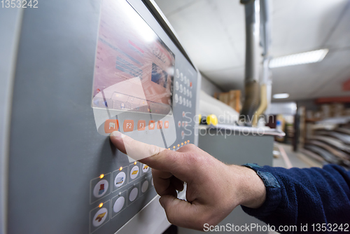 Image of carpenter calculating and programming a cnc wood working machine