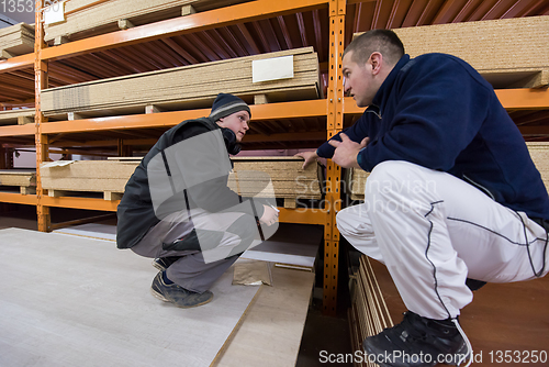 Image of two young carpenters writing new prices