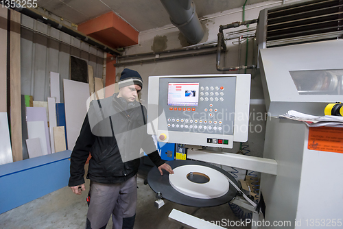 Image of carpenter calculating and programming a cnc wood working machine