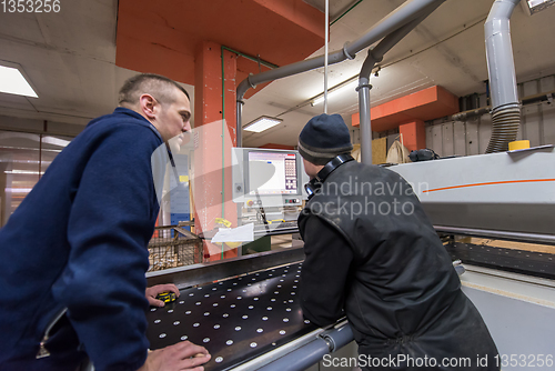 Image of carpenters calculating and programming a cnc wood working machin