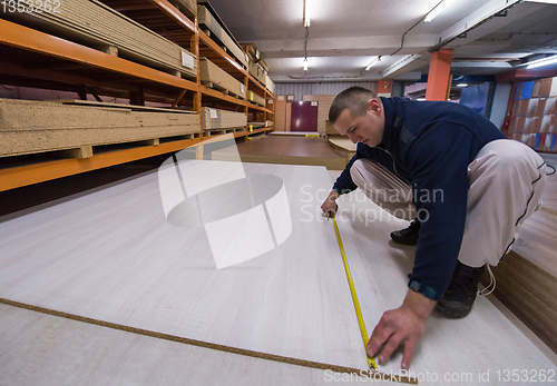 Image of carpenter measuring wooden board