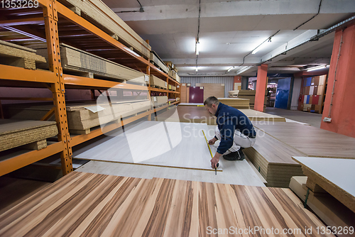 Image of carpenter measuring wooden board