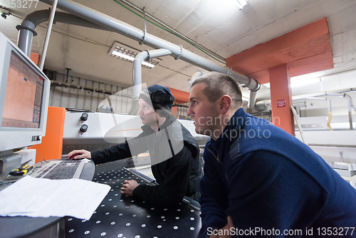 Image of carpenters calculating and programming a cnc wood working machin