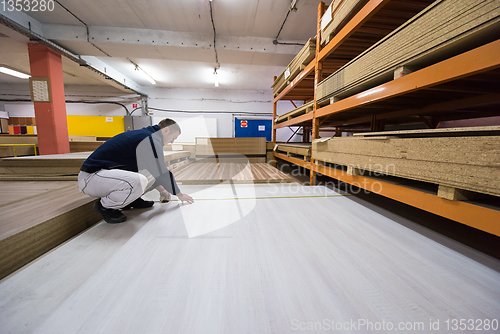 Image of carpenter measuring wooden board