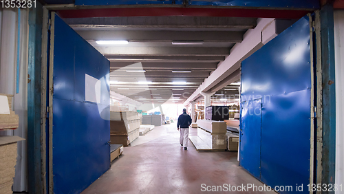 Image of carpenter walking through factory