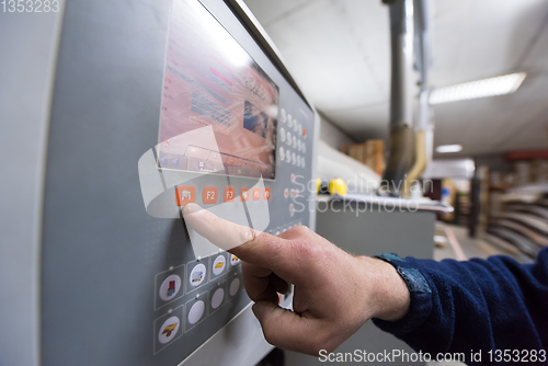 Image of carpenter calculating and programming a cnc wood working machine