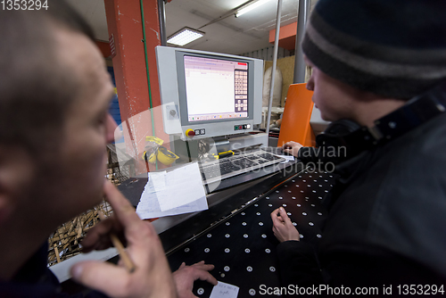 Image of carpenters calculating and programming a cnc wood working machin