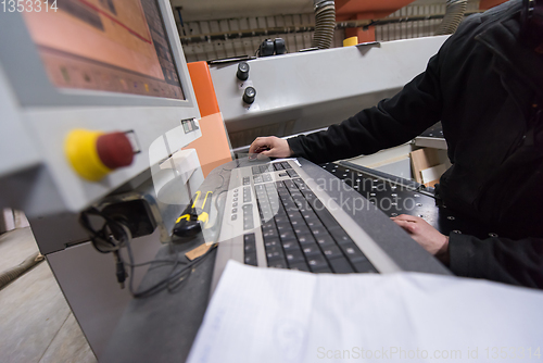 Image of carpenters calculating and programming a cnc wood working machin