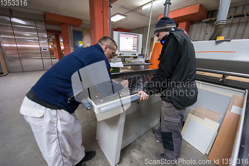 Image of carpenters calculating and programming a cnc wood working machin