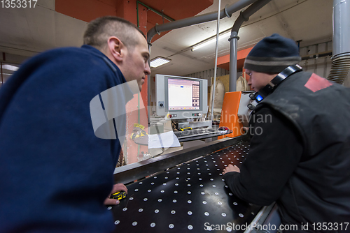 Image of carpenters calculating and programming a cnc wood working machin