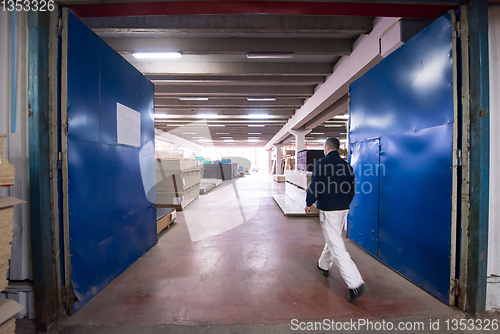 Image of carpenter walking through factory