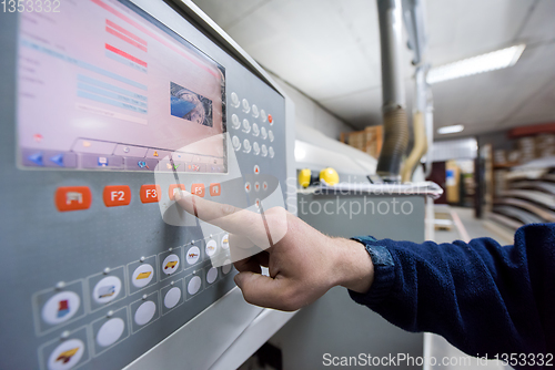 Image of carpenter calculating and programming a cnc wood working machine