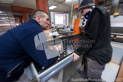 Image of carpenters calculating and programming a cnc wood working machin