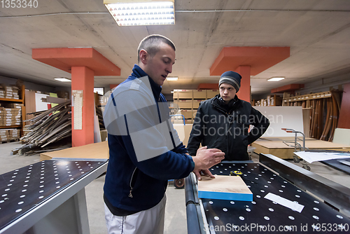 Image of carpenters calculating and programming a cnc wood working machin