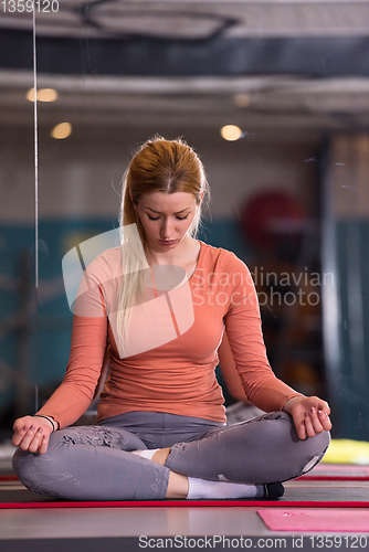 Image of sportswoman doing yoga exercise and meditating