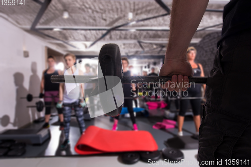 Image of sporty women using barbells while exercises