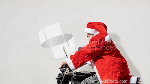 Image of man on a motorbike in a typical Santa Claus costume