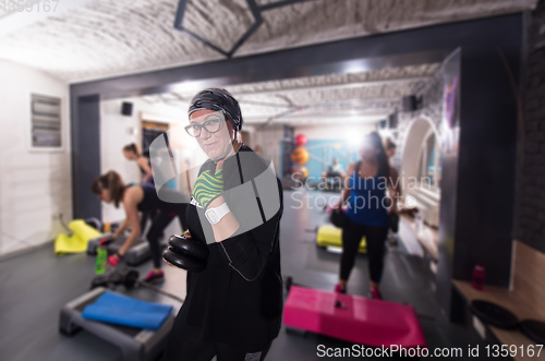 Image of sporty woman holding a metal round weights plate