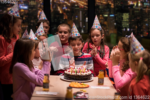 Image of happy young boy having birthday party