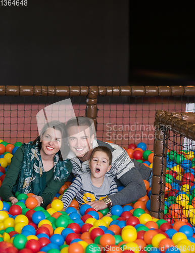 Image of parents and kids playing in the pool with colorful balls