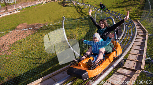 Image of young mother and son driving alpine coaster