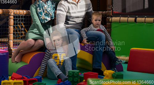 Image of young parents and kids having fun at childrens playroom